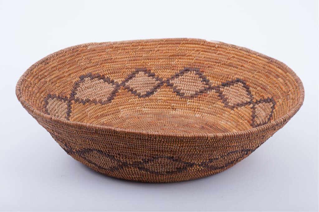 Native American Coil Basket: Late 19th/Early 20th century. 16 1/2" Diameter. 4 1/2" height. Condition: Wear and some losses to rim. Other minor losses and some staining.