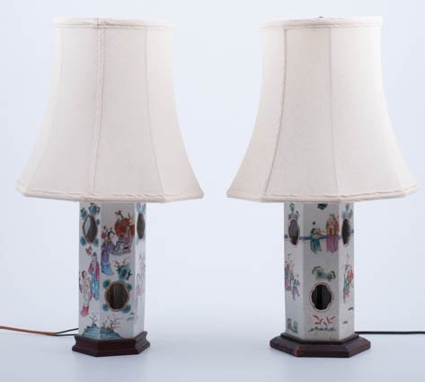 Pair of Chinese Famille Rose Table Lamps: Hexagonal porcelain lamps with Famille Rose design, 10 1/2" high, on wood base, brass works, with shades. Condition: Minor wear. Lamp hardware are not identical.