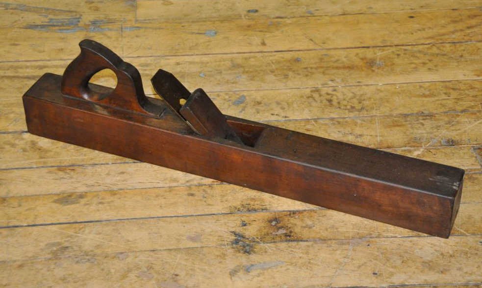 Pe'Jgeot Freres Jointer Plane: A cherry wood jointer plane, 26 1/2” x 2 7/8”. The blade is marked with a stamp 'coeur' which translates as 'heart' in French. It also has the Pe'Jgeot Freres stamp, with a lion walking on an arro