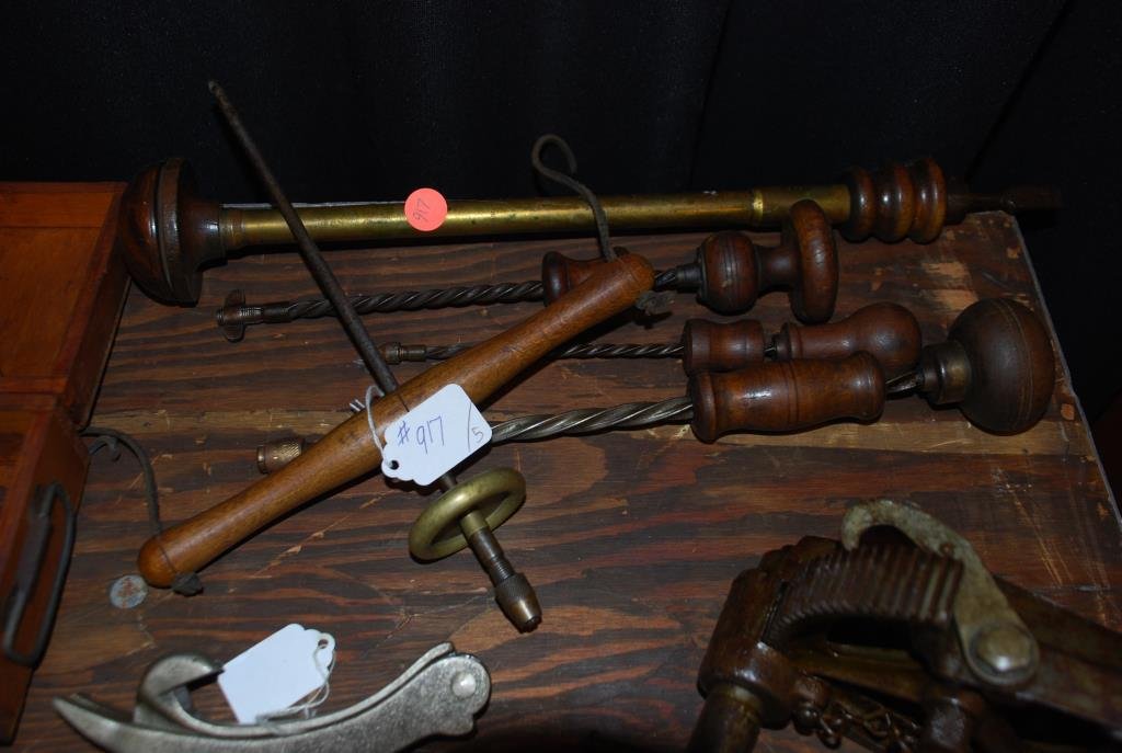 Five Early Drills: One pump drill with a brass flywheel, the leather string has broken. And, four Archimedean style drills. The longest measures 15” and has a brass shaft with an exotic wood head. Condition: fair