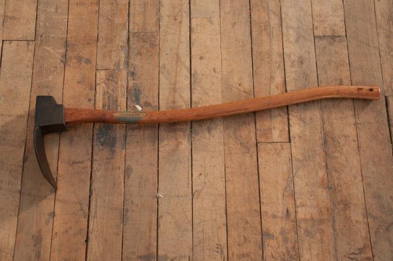 Carpenters Adze: 4 1/2” wide metal adze. The head is 9” long, and the handle measures 33 1/2”. It has its original handle, with a label that reads 'Excelsior' and was sold by the Smith Brothers Hardware Co. Colu