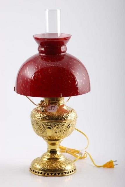 Edward Miller Brass Table Lamp: Miller stand lamp reticulated and fully embossed. Height 17 inches. Condition: Good: Electrified without harm. Red with metallic fleck shade is a later replacement