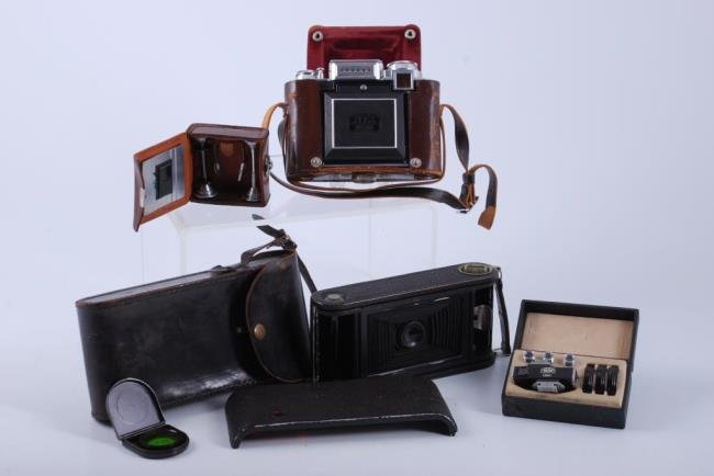 Lot of 2 Vintage Cameras & Accessory: Zeiss Ikon Super Ikonta medium format camera with original leather case and film spool accessory. Ansco Bionic folding camera. Condition: Zeiss is in very good condition needs calibration. The Ansco i