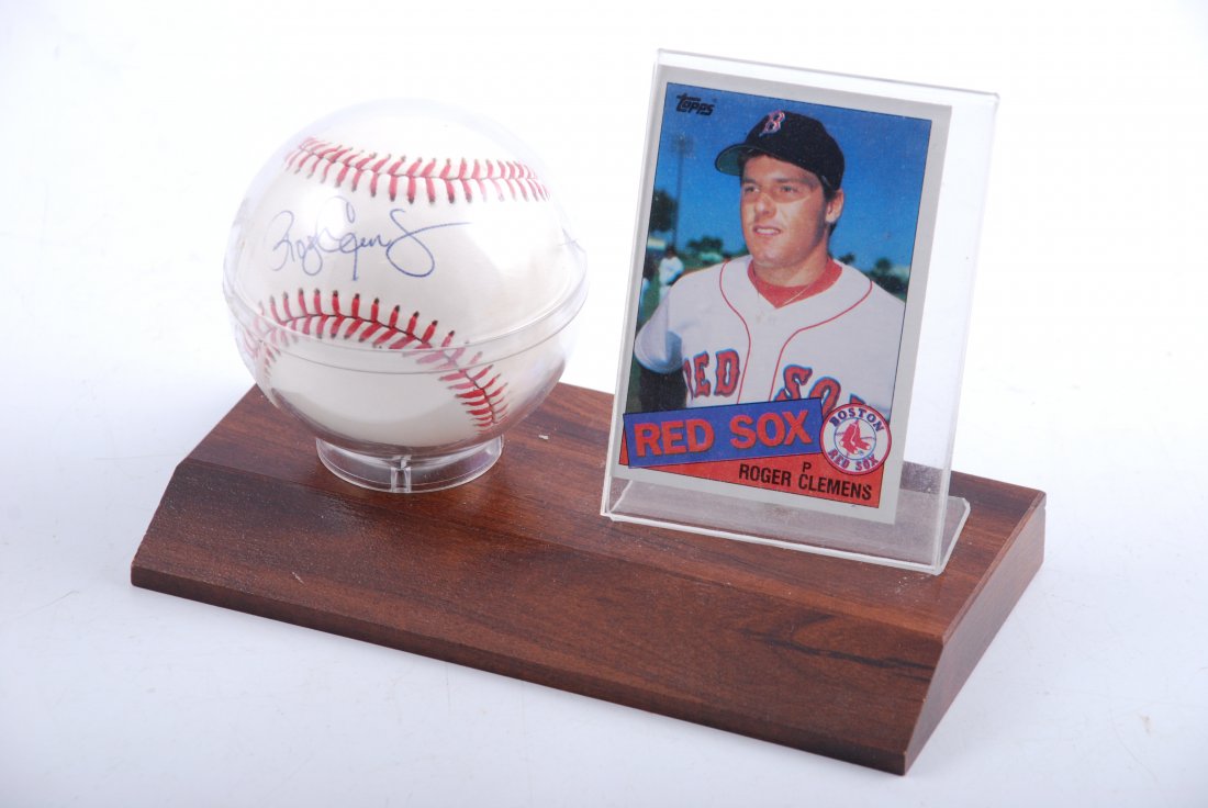 Roger Clemens Signed Baseball: Official American League ball autographed "Roger Clemens". Comes in a display stand alongside a 1985 Topps baseball card.