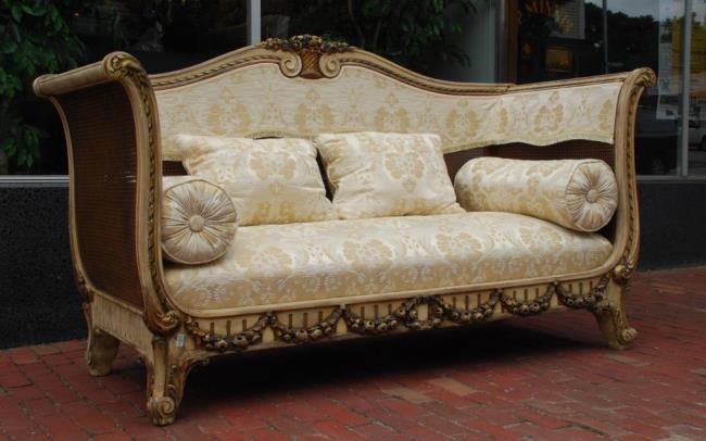French Carved and Painted High-Back Sofa: High-back caned and damask silk upholstered sofa with carved floral basked centering a scrolled crest. Carved lyre form arms and apron with carved floral swags. 46 x 80 x 30 inches. Condition: Good, d