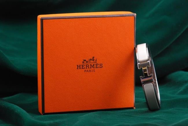 Hermes Enamel Bracelet: Hermes white enamel bracelet in original box Condition: minor flake in enamel at back hinge Size: Approx. 6 3/4 inch interior and just under 1/2 inch wide