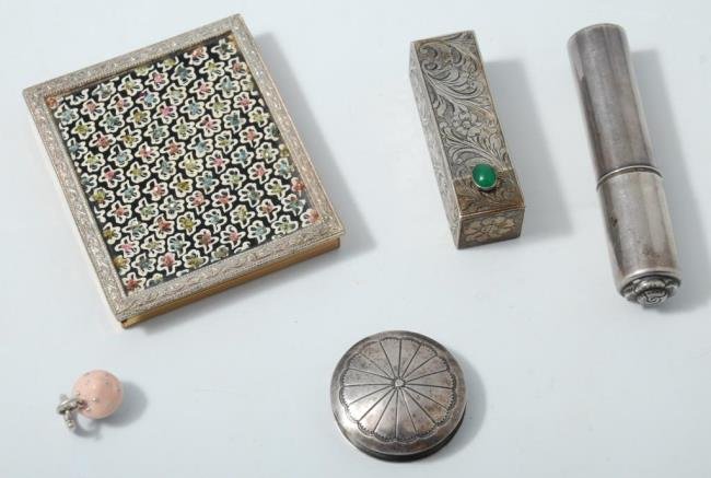 Group of Sterling Vanity Items: An .800 silver lipstick, sterling atomizer, a silver pill box, a compact and a Tiffany & Co. sterling cupcake charm Condition: Good Size: compact is approx. 2.25 inches by 3 inches