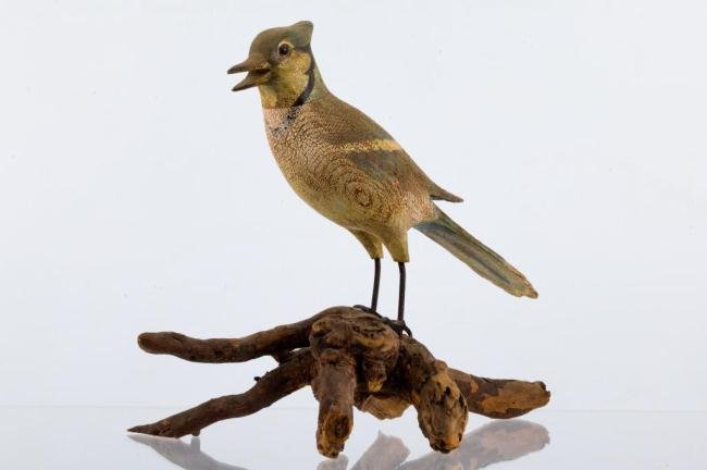 EARLY 20th c. HAND CARVED AND PAINTED BLUE JAY: Glass eyes and iron legs displayed on a natural wood root base. Height 10 1/2 inches