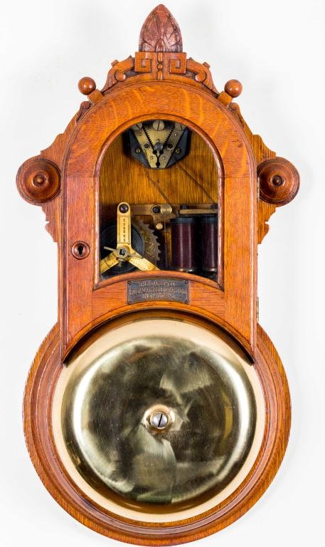 GAMEWELL FIRE ALARM TELEGRAPH CO NY TELEGRAPH: Aesthetic movement carved and turned oak case with glazed door opens to patented key wind Gamewell of New York telegraph mechanism. Height 22 inches. 9 inch bell.