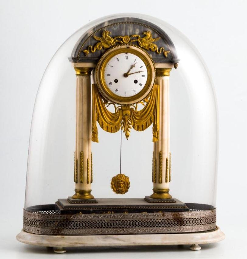 FRENCH EMPIRE GILT BRONZE AND MARBLE MANTLE CLOCK: Elaborate marble and ormolu mounted shelf clock with (2) fluted marble columns and arched entablature with cast winged sea horses supporting an unsigned movement with enameled dial, draped swags and o