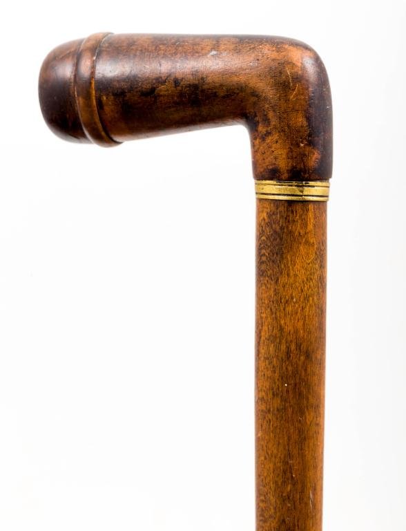 "PIPE" CANE OF TURNED WOODS: 3 1/2 inch turned ""L"" handle is ended with a turned screw cap which opens to tobacco bowl. Contrasting hardwoods meet at brass collar. The hollowed shaft is decorated with (3) concentric rings. Leng