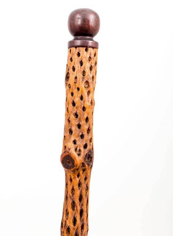 CANE WITH EXOTIC WOOD SHAFT: 1 3/4 inch turned rosewood knob handle with an exotic naturally porous wooden shaft Length 34 1/2 inches