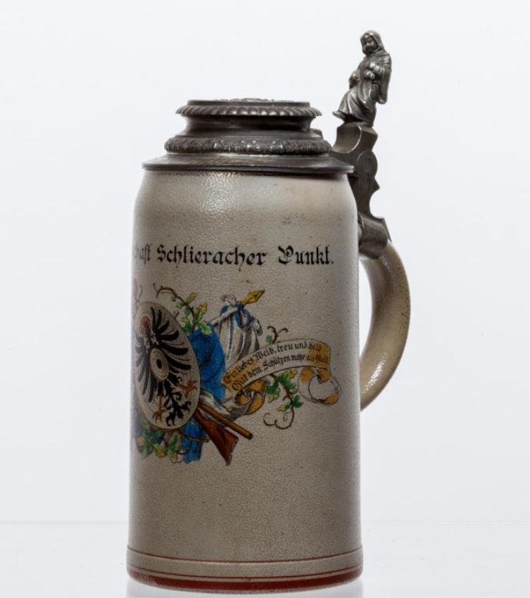 1 LITER SALT GLAZED STEIN WITH MONK: Schutzengesellschaft Schlieracher Punkt"" Polychrome transfer decorated with shield, guns and flags. Pewter lid with monk and low relief figural scene. Height 9 1/2 inches