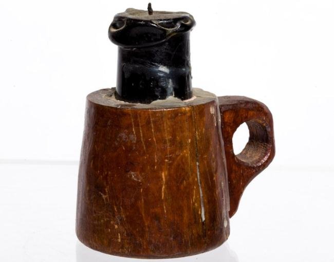 MAKE-DO FINGER LAMP: Early blown green glass bottle shard candle socket is incorporated into a solid carved hardwood treen base with applied wooden ring handle. Height 4 1/2 inches