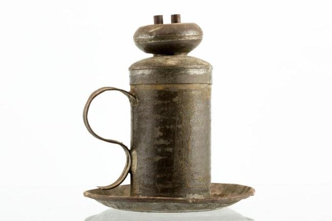 TIN JESSE NEAL LARD CANDLE LAMP: A newspaper clipping advertising this lamp accompanies the lot. Height 5 1/2 inches