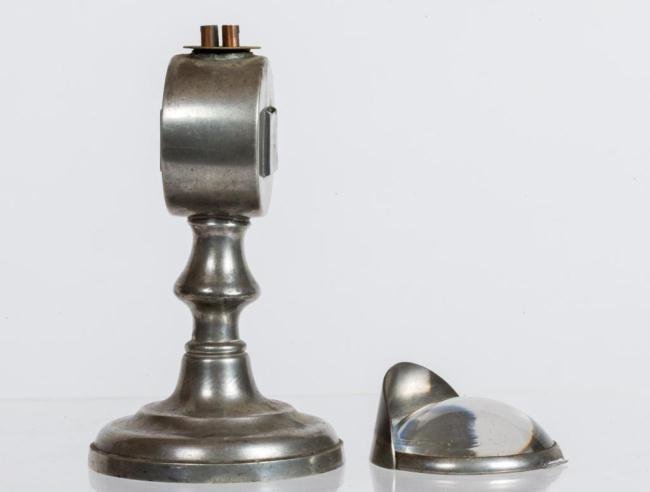 R. GLEASON PEWTER BULLSEYE WORK LIGHT c.1830: Cylindrical font with (2) slots to receive polished convex glass magnifying lens with visor. Turned standard and weighted base is stamped "R. Gleason". Height 7 inches