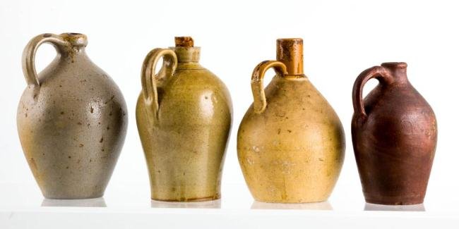 (3) STONEWARE JUGS AND (1) REDWARE JUG: Stoneware jugs both ovoid and bulbous with interesting necks and applied handles. Ovoid red ware jug is paint decorated with heirloom roses. 8 inches and under