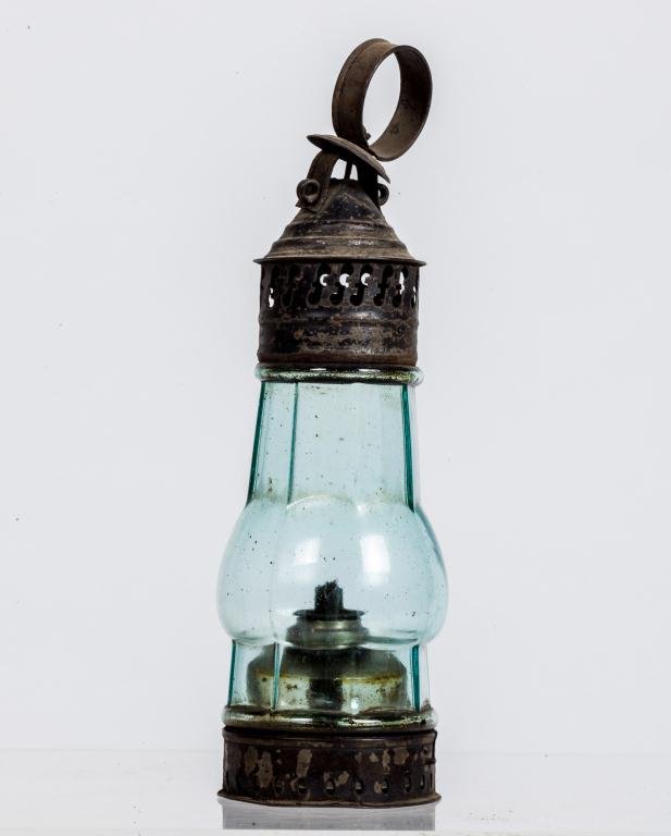 DEMURE BLOWN MOLDED OCTAGONAL PIERCED TIN LANTERN: Black painted pierced tin lantern with clear green octagonal and onion-waisted glass globe. It retains its original blown molded glass whale oil burner. Height 11 1/2 inches