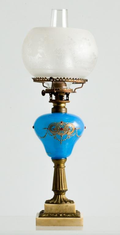 TABLE LAMP WITH UNIQUE BURNER: Blue blown molded font decorated with gold enamel and red beads, reeded brass tapered standard and marble base. Globe etched with horses in a landscape (5 inch fitter). Interesting ""Unique"" Plume an