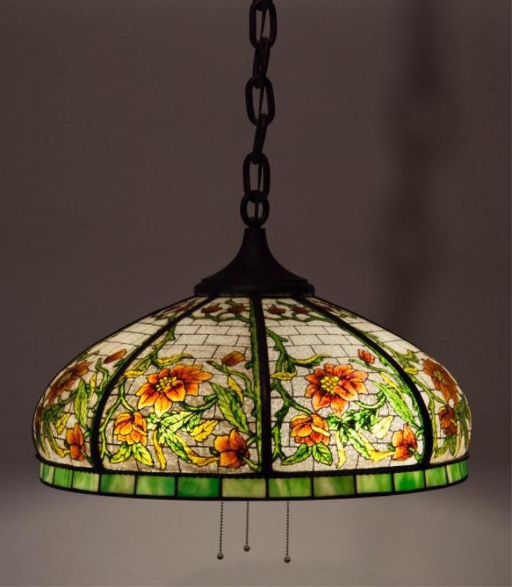 EARLY 20th c. REVERSE PAINTED HANGING CEILING FIXTURE: Bronzed three-socket light fixture. Shade made from a bronzed frame with (8) curved reverse painted floral panes and rimmed with small panes of green and white slag glass. The glass shade's exterior h