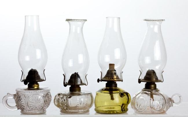 (4) BLOWN MOLDED AND PRESSED GLASS FINGER LAMPS: (2) Embossed fonts and (2) with embossed bases (1) being a light clear yellow-green. Height under 3 1/2 in.