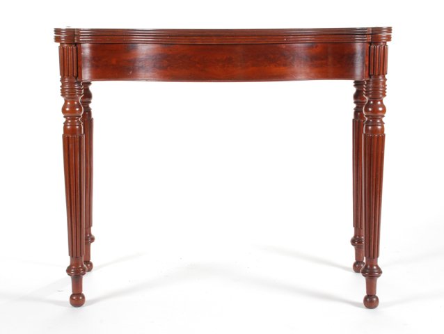 (19th c.) Sheraton Mahogany Card Table: Molded serpentine top, cockbeaded crotch mahogany apron with turned and reeded offset legs. 29 1/2 x 35 x 18 inches. Condition: Good