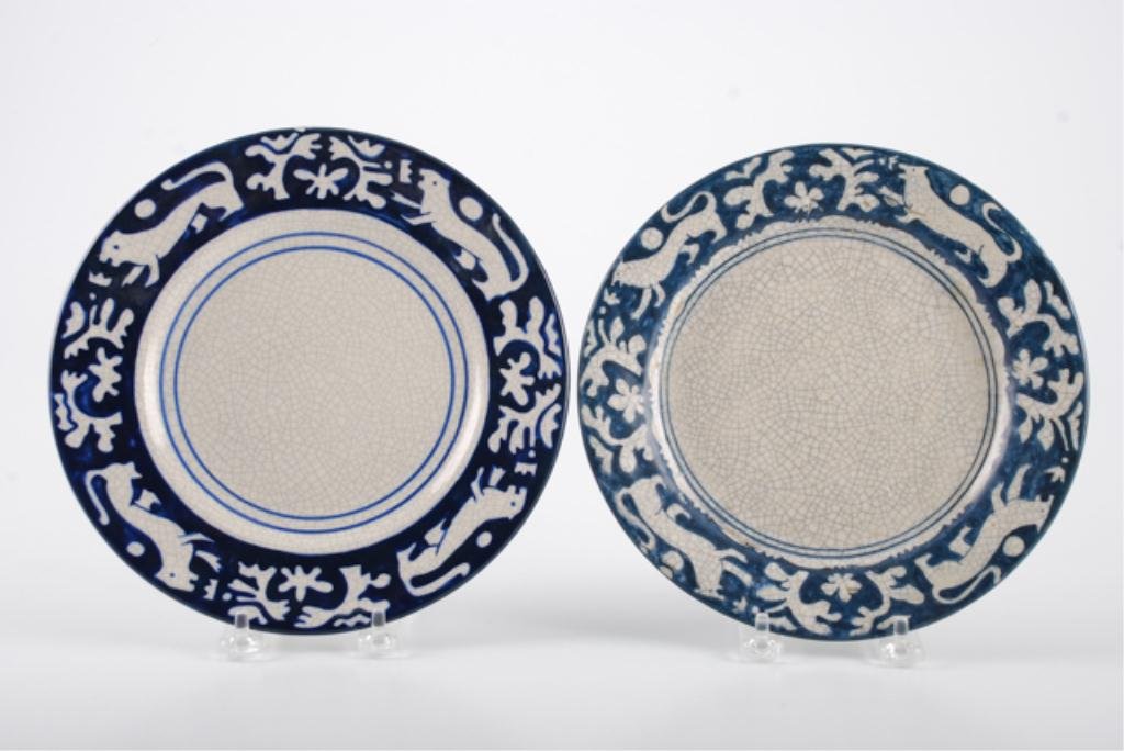 (2) Dedham Pottery Plates w/ Lion Tapestry Borders: (1) 8 3/8 inch crackleware plate marked with pre-1929 insignia and (1) 8 5/8 inch centennial edition plate signed and dated 1996. 97/300. Condition: Early plate has glaze imperfections primarily to bo