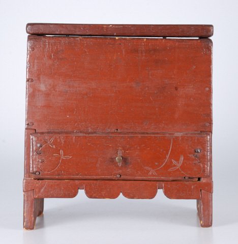(19th c.) Miniature One Drawer Blanket Chest: Reddish brown paint with top fitted with snipe hinges, drawer pegged and carved., scalloped apron 12 1/2 x 11 x 6 inches. Condition: Good