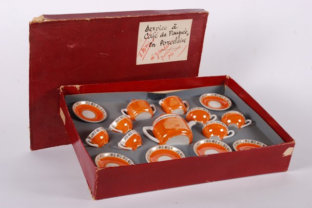 Antique French Porcelain Doll\'s Tea Set / Original Box: Orange painted tea set with gold filigree borders consisting of a tea pot, creamer, sugar and (6) cups and saucers. Box titled \"Service a Café de Poupee en porcelain\"