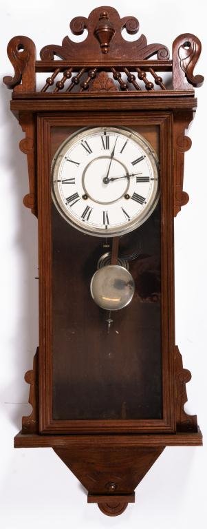 Waterbury Clock Co. Walnut Wall Clock: 8 Day time and strike spring driven movement. height 38 inches.