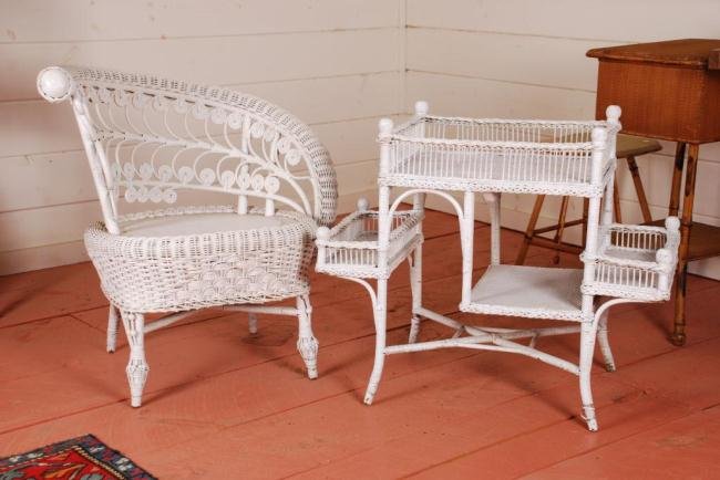 Wicker Arm Chair & Wicker End Table: Painted white. Chair with serpentine arms, one curving downward. The end table has multiple shelves and measures: x 31 1/2 x 27 inches.