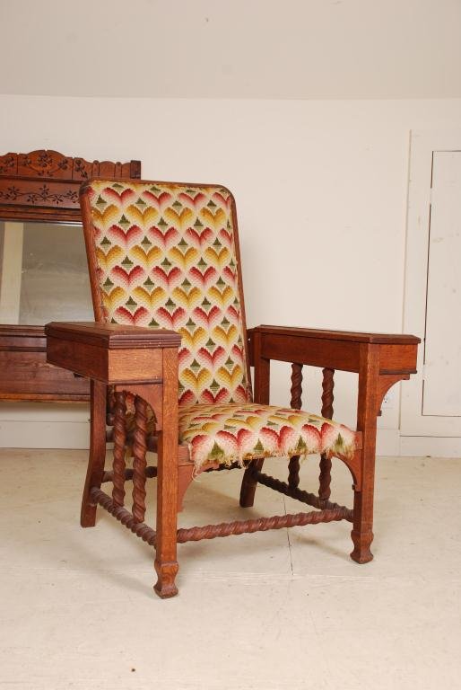 Oak Morris Chair: With square legs, barley-twist turnings, flame stitch back and seat; right armrest opens to a writing surface- left armrest is a lift-top box.