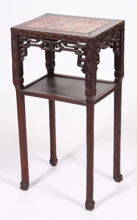 LATE QING CHINESE ROSEWOOD MARBLE TOP STAND: Circa 1890, foliate carved rectangular top inset with rouge marble above geometric openwork panels, raised on turned carved legs with ball and claw feet joined by a lower tier, 32 x 16 x 12 inches.