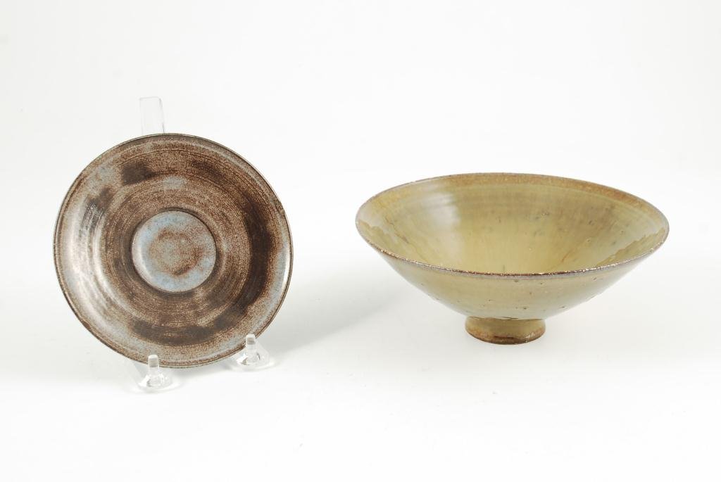 ED AND MARY SCHEIER POTTERY BOWL AND SAUCER: Each signed. Bowl is 2 7/8 x 7 1/4 inches. Saucer uses an early dark brown clay beneath a milky blue glaze.