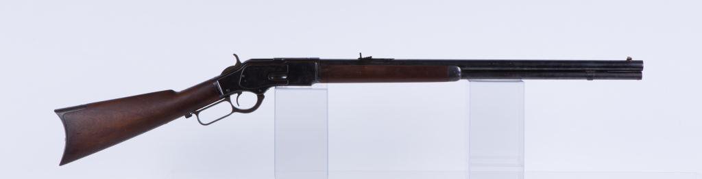 WINCHESTER MODEL 1873 ROUND BARREL RIFLE: 3rd model 1873 rifle, full magazine, .38 cal, 24 inch round barrel, blue finish, dust cover, standard sights, step down receiver, crescent butt and steel forged end cap with sliding brass ammo hold. s