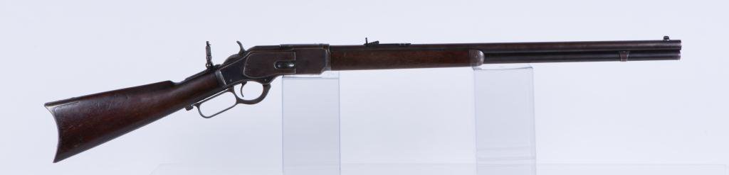 WINCHESTER MODEL 1873 ROUND BARREL RIFLE: 1888 3rd model 1873 rifle, full magazine, .38 cal, 24 inch round barrel, blue finish, dust cover, standard sights, step down receiver, crescent butt and steel forged end cap with sliding brass ammo ho