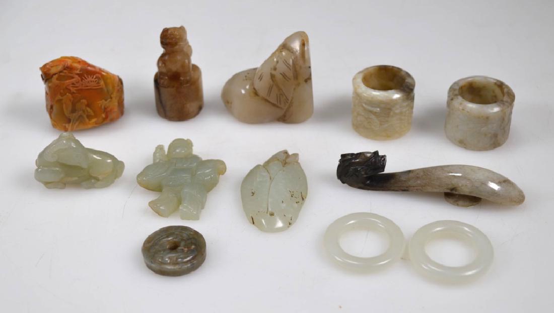 12 - Antique Chinese Carved Jades & Hardstones: 12 - Antique Chinese Carved Jades & Hardstones; a pair of white jade rings, two chicken bone jade archer's rings and a Dragon Belt Hook, 5 jade pendants, a hardstone seal and a soapstone seal. Light a