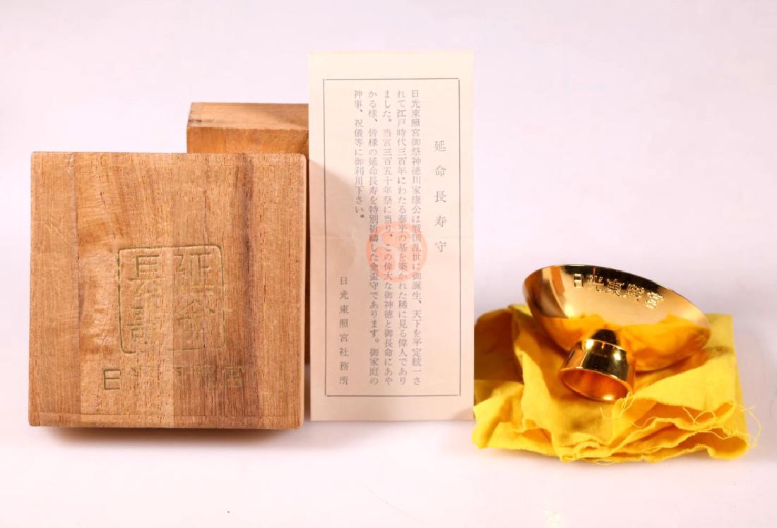 Japanese Wine Cup marked 24K GP: Japanese Wine Cup marked "24K GP" on the base, the sides with a 5-character mark molded; with Japanese wood staorage box.. Diameter 2 1/4 inches (5.8 cm.).