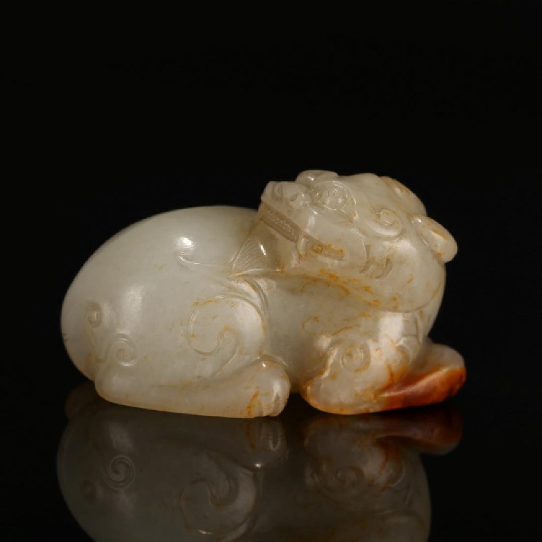 Chinese Carved "Magic Animal" Jade Pebble: Chinese Carved "Magic Animal" Jade Pebble with small areas of russet jade; hole between front paws. Weight 97 grams. Width 2 1/4 inches (5.7 cm.).