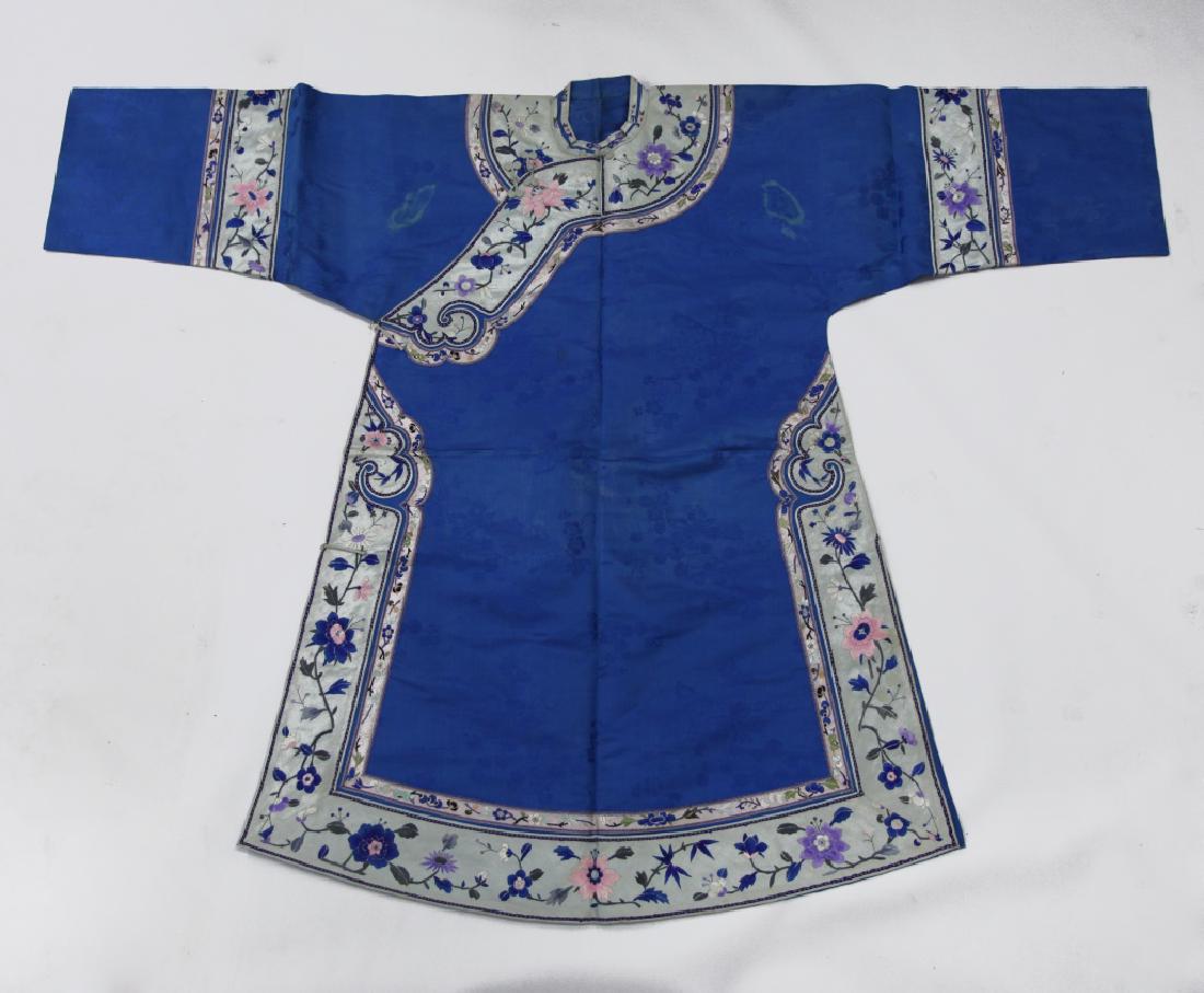 Chinese Late Qing Silk Embroidered Robe: Chinese Late Qing Silk Embroidered Robe in blue silk damask with grape vine design and borders of satin stitch flowers with a Ruyi collar closed with silk cord knots. Good condition with a small disco