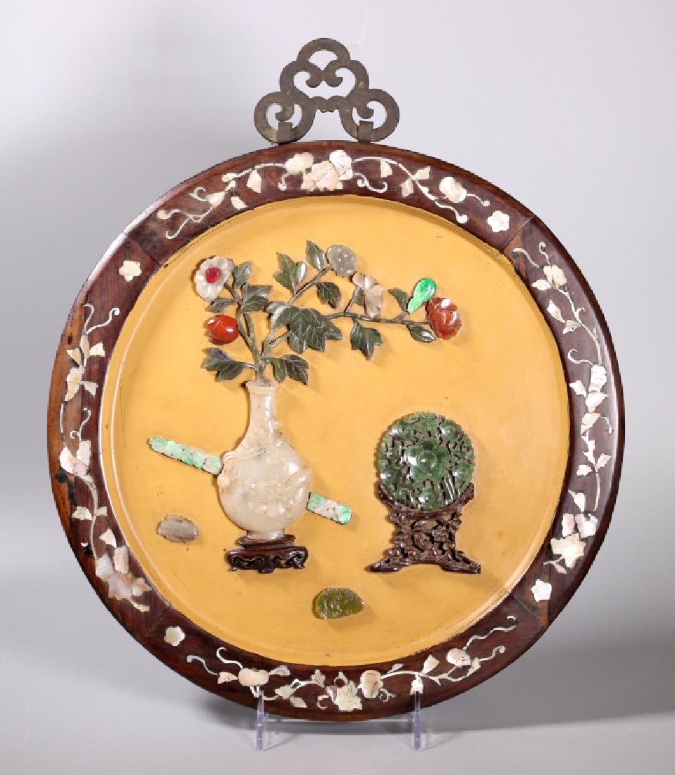 Chinese Round Wall Plaque; 19C Hardstone Carvings: Chinese Inlaid Hardwood Round Wall Plaque with bronze Chinese hanger at top; the inside of the circle in yellow polished lacquer and with a design of carved antiques in 19 Century Hardstone Carvings i