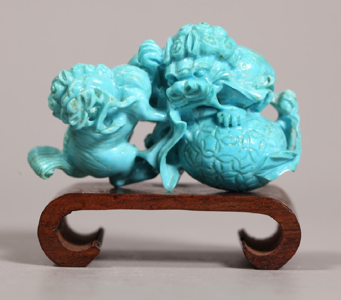Chinese Carved Quality Turquoise Fu Dogs; 51.9G: Chinese Carved High Quality Turquoise Fu Dogs (Buddhist Lions) climbing on a brocade ball; with small scroll-shaped hardwood stand. Weight of turquoise 51.9 grams. Good condition with light age relate