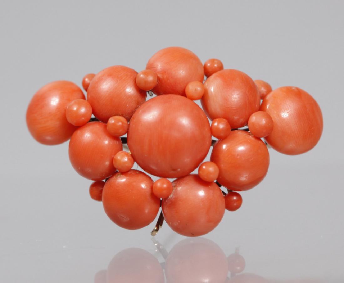 Victorian 19 Century Coral & Gold Brooch; 16.2G: Victorian 19 Century Coral & Gold Brooch with 10 round cushion shaped polished corals and 14 small polished corals, the back with gold pin on gold frame with 3 tiny hooks for further pendants. Total w