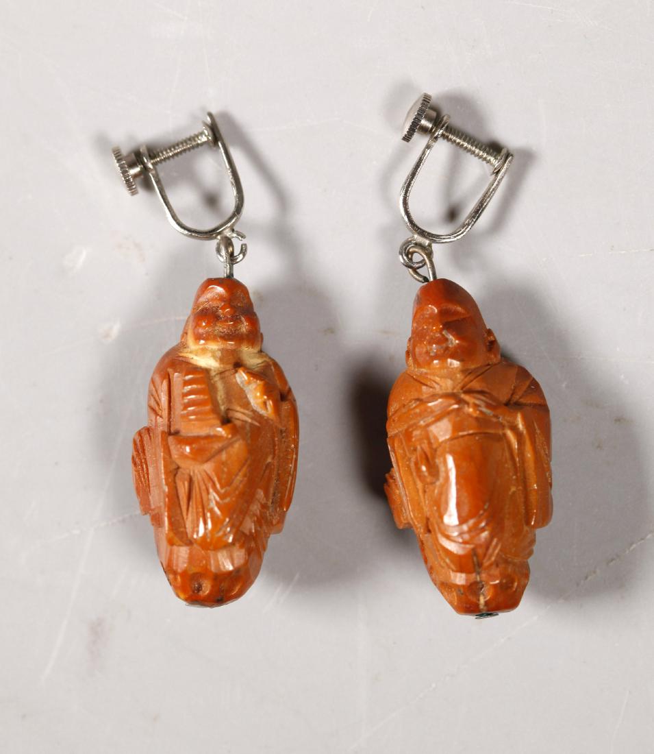 Pr Chinese Peach Pit Buddhist Lohan Bead Earrings: Pair Antique Chinese Peach-Pit Buddhist Lohan Bead Earrings. Light age related wear and 1 with 1 small shrinkage crack. Height 1 1/4 inches (3.2 cm.).