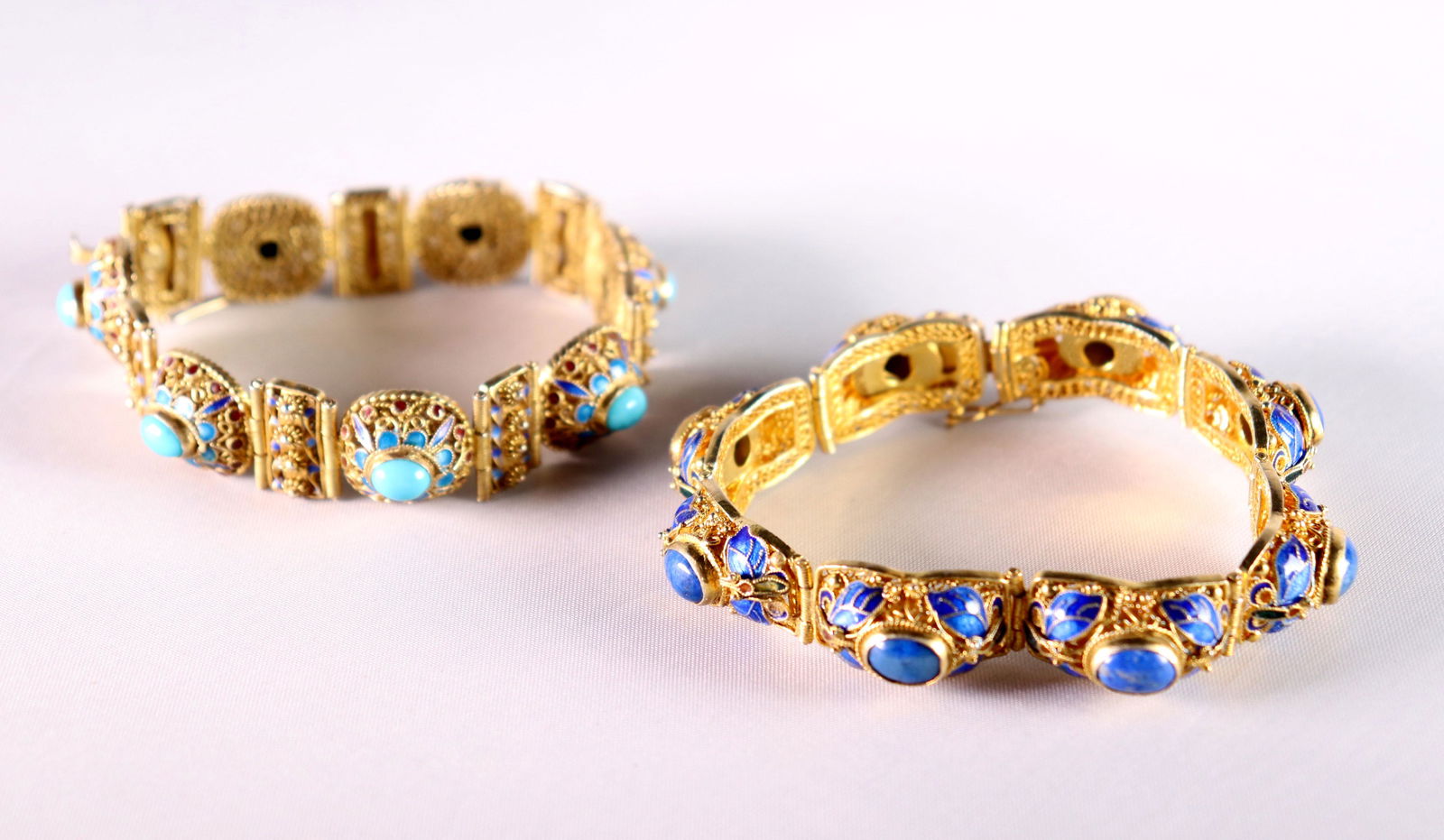 2 Chinese Gilt Silver Wire & Enamel Link Bracelets: 2 Chinese Gilt Silver & Enamel Wire Link Bracelets, one set with Lapis Lazuli oval cabochons and blue enamel, the other with bright turquoise cabochons and turquoise enamel. Both with safety catch to