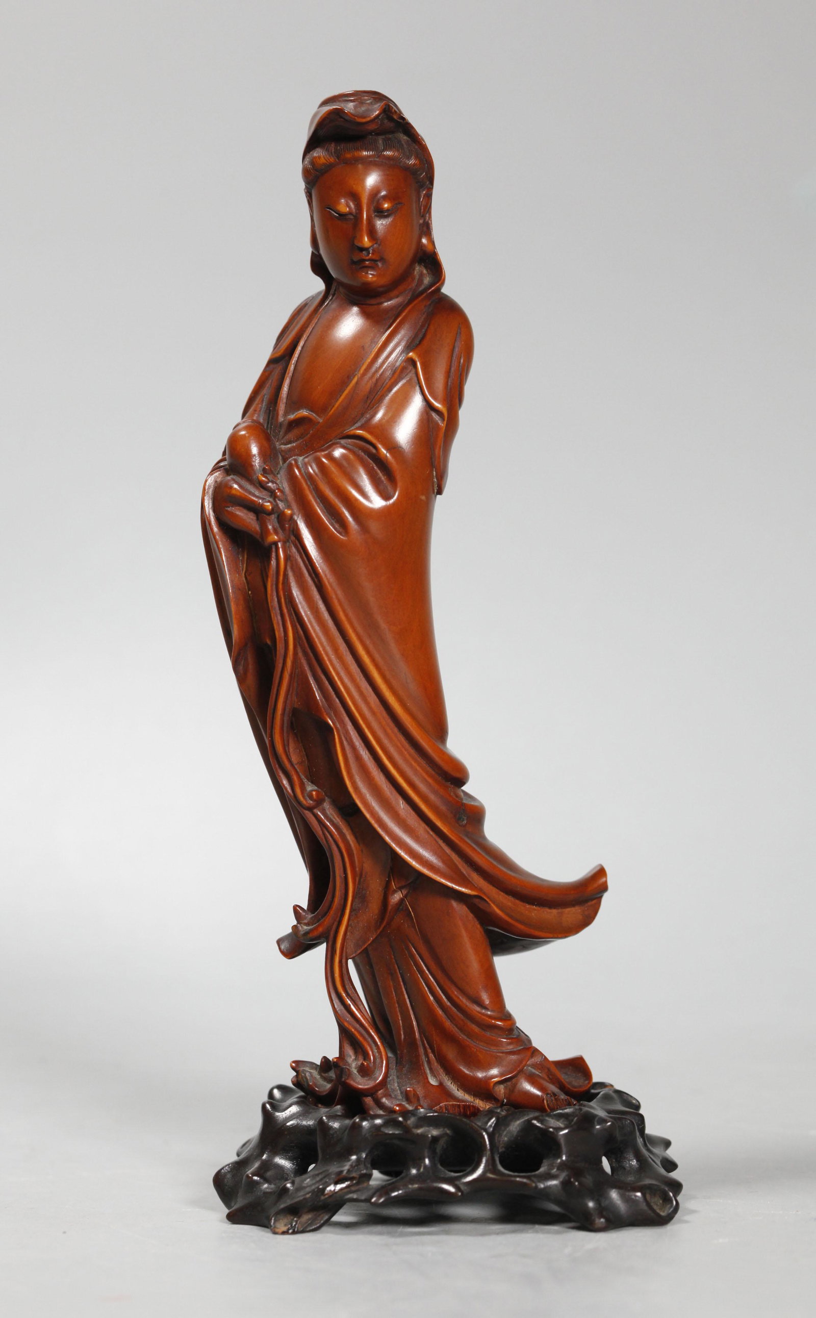Chinese Qing Boxwood Standing Guanyin & Base: Chinese Qing Dynasty Boxwood (Huangyangmu) Standing Guanyin pouring from her vase of compassion, on separate custom hard wood base. Short shrinkage lines with the grain, 3 small chips at base and 1 to