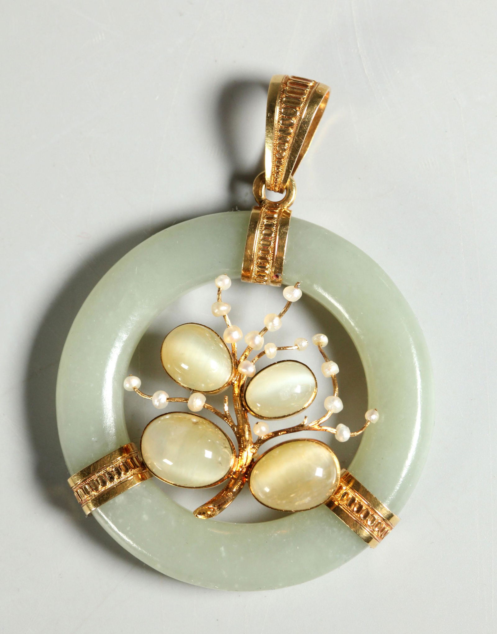 Chinese Antique Jade 18K Moonstone Pearl Pendant: Chinese Antique pale celadon Jade ring Pendant mounted in yellow gold marked "750", the center set with 4 oval Moonstone cabochons and small seed Pearls in imitation of fruit and flowers on a carved g