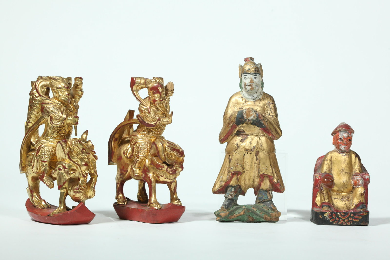 4 Chinese Gold & Red Lacquered Wood Figures: 4 Chinese Gold & Red Lacquered Wood Figures, a pair of Guardian Figures on Mythological Animals, a Standing Guardian and a Seated Sage. Height of largest 5 3/4 inches ( 14.5 cm.).