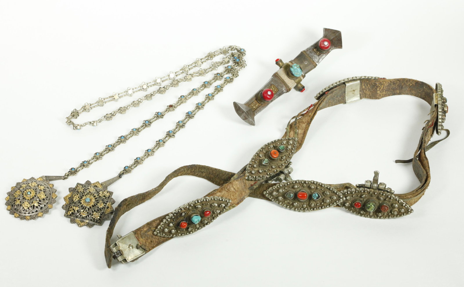 Tibetan Silver Gold & Iron; Belt, Knife, Medalions: Tibetan Silver, Gold & Iron; a leather Belt and buckle with 6 silver belt slides with corals and turquoise, 2 of which have drop rings, a curved iron Knife, and 2 gilt iron Medalions attached to a lin