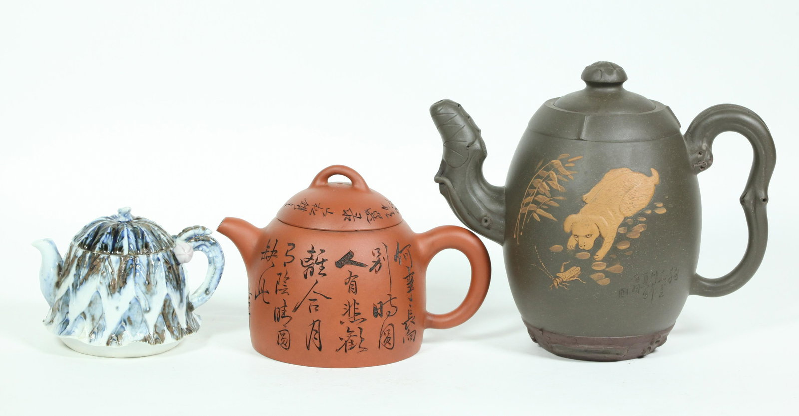3 Chinese Teapots: 2 Yixing, 1 Porcelain: 3 Chinese Teapots: 2 Yixing, a tall teapot in dark clay with Dog & Cricket in light clay and incised calligraphy to the reverse, seal mark to base, and an incised teapot with calligraphy to sides and 